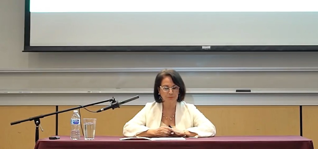 Parissa seated at the lecture table with Stanford University branding — Bishop Auditorium, Stanford Festival of Iranian Arts, 2019